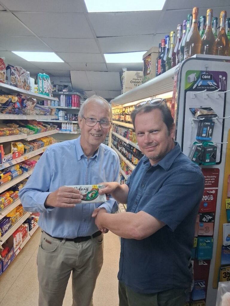 Howard handing John a bar of Galaxy mint chocolate